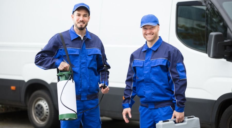 pest control men in front of a white truck