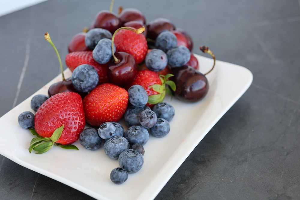 plate of berries and cherries